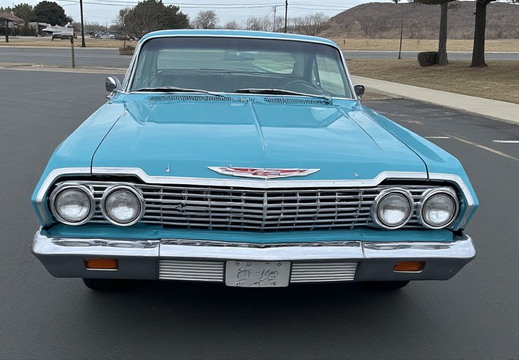 A vintage turquoise Chevrolet Impala parked outdoors