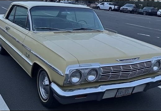 Pale yellow Chevrolet Impala parked in an asphalt parking lot. 