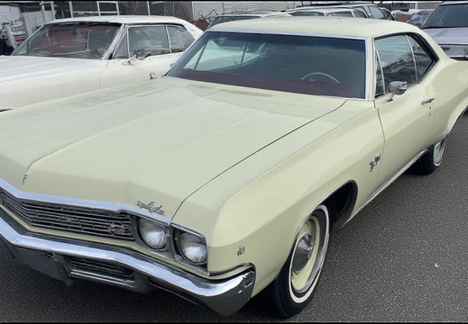 A pale yellow classic American car from the late 1960s