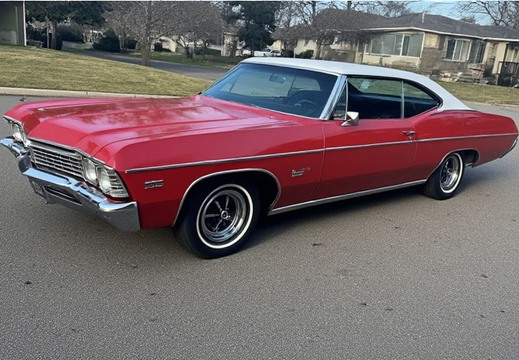A vintage red and white Chevrolet Impala